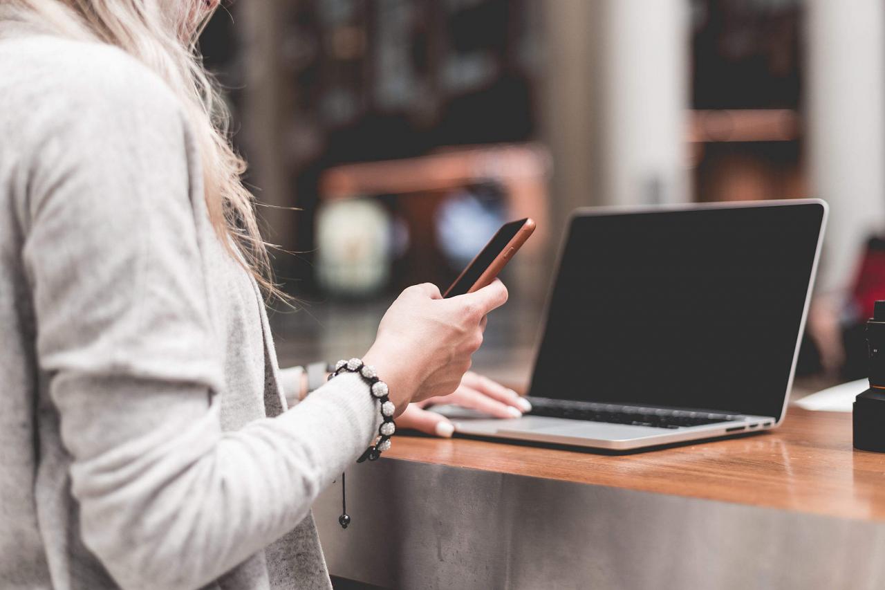 b52d3a93773babd012ee woman-using-her-smartphone-while-working-remotely-on-laptop_free_stock_photos_picjumbo_HNCK2998-2210x1474